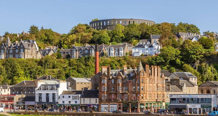 View of Oban with houses on a hill and McCaig's Tower.