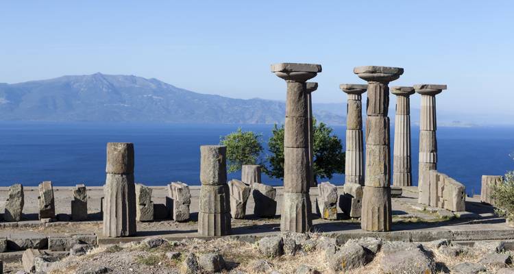Verwoeste Dorische zuilen van de Tempel van Athena in Assos met uitzicht op de Egeïsche Zee en verre bergen.