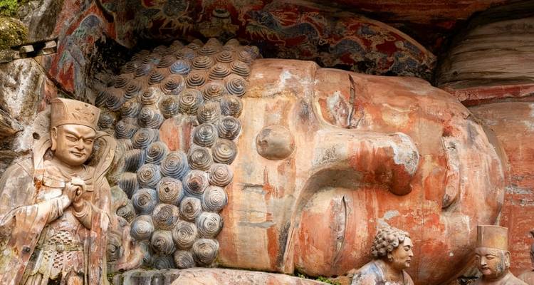 Statues carved into a rock face.