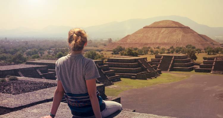 Reisender, der auf einem Steinsims sitzt und die Pyramide der Sonne in Teotihuacán überblickt
