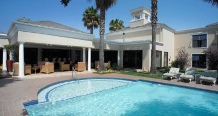 Outdoor pool area at a lodge with lounge chairs.