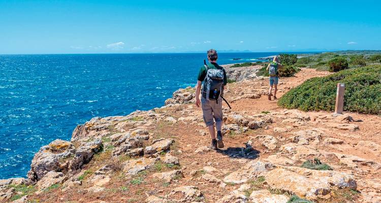 People hiking along a coastal path with ocean views.