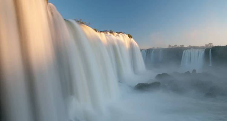 Iguazu-Fälle mit sanftem Wasserfließ-Effekt bei Sonnenaufgang.