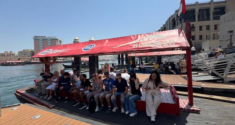 People seated on a boat at a busy dock.