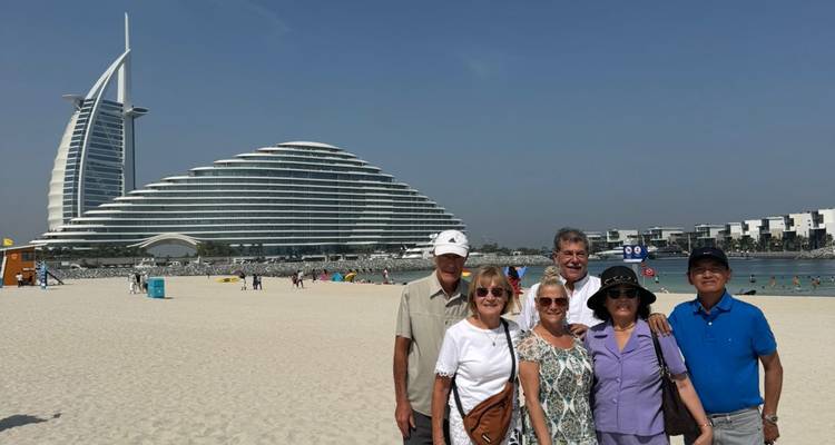 Group enjoying beach near iconic hotel.