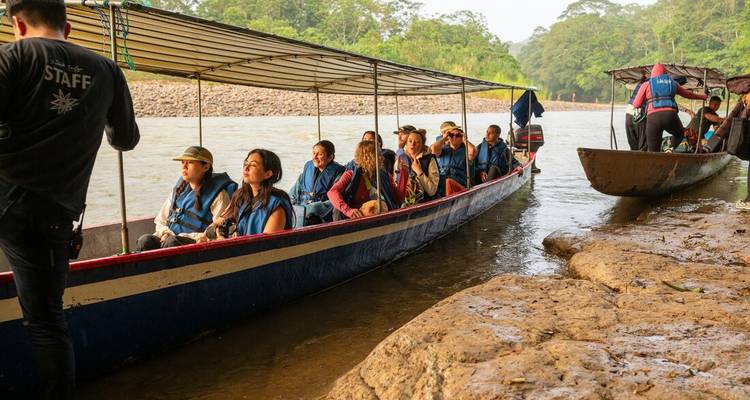Group of tourists on a river boat journey through the forest.