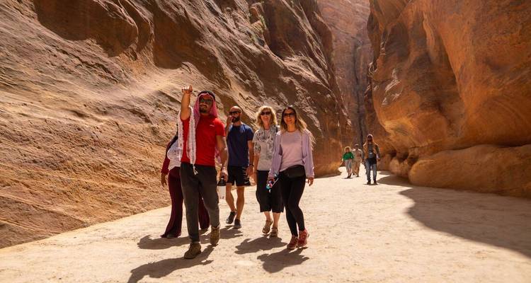 Un groupe de touristes marchant à travers un canyon rocheux.