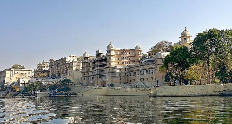 Un grand et élégant bâtiment avec des dômes et une architecture complexe au bord de l'eau.