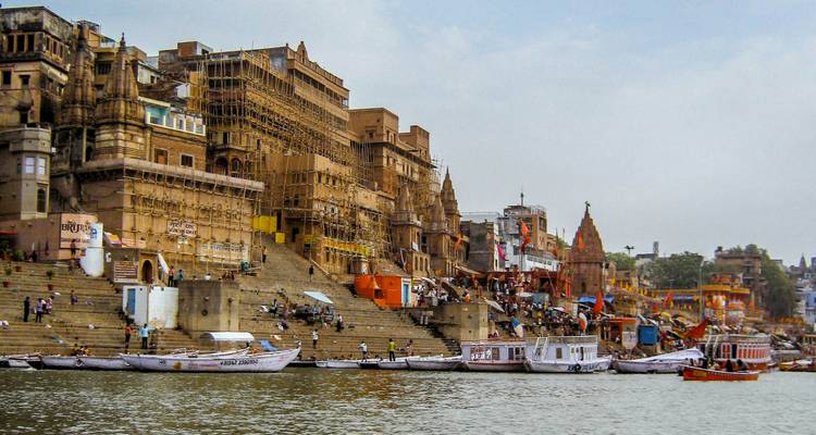 Ghats animés à Varanasi avec des bateaux et des bâtiments le long de la rivière.