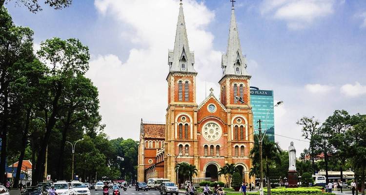 A historic cathedral surrounded by a busy city street during the day.