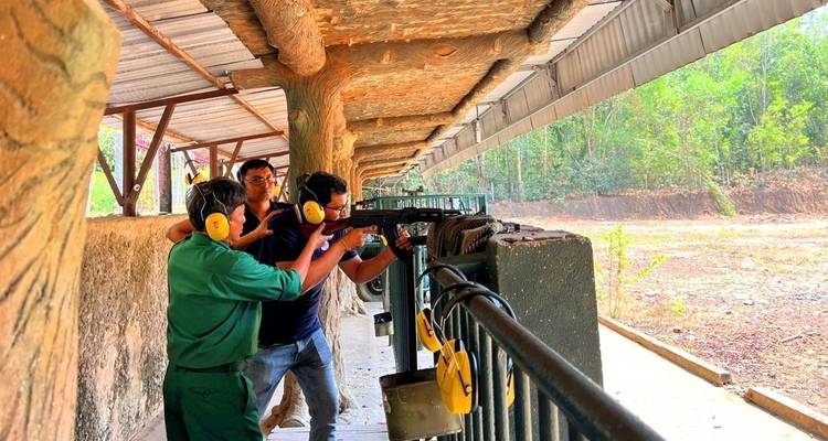 People at a shooting range with rifles pointed at a target.