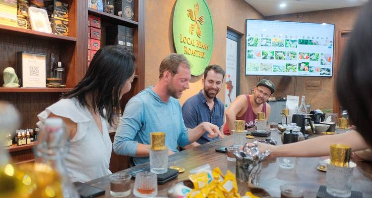 Four people sitting at a table enjoying drinks in a coffee shop.