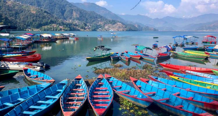 Des bateaux colorés sur un lac avec des montagnes en vue