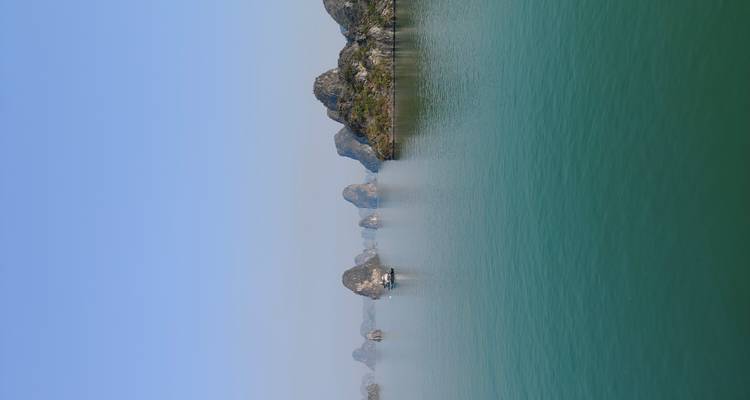 Emerald waters and towering limestone karsts of Halong Bay under clear skies