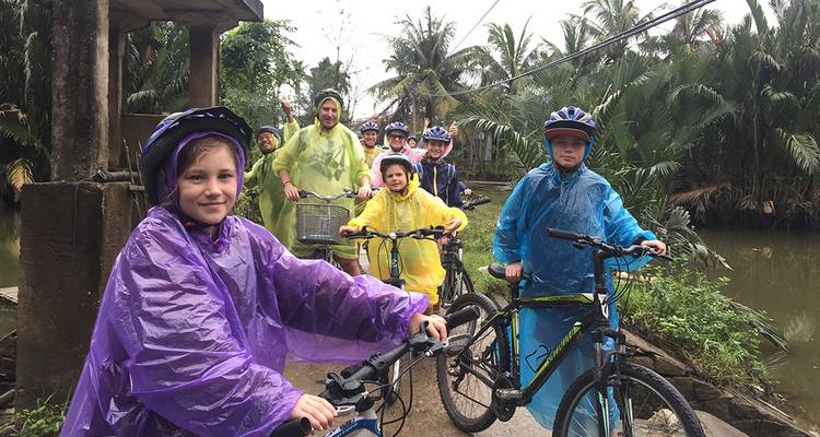 Group of children on bicycles wearing raincoats