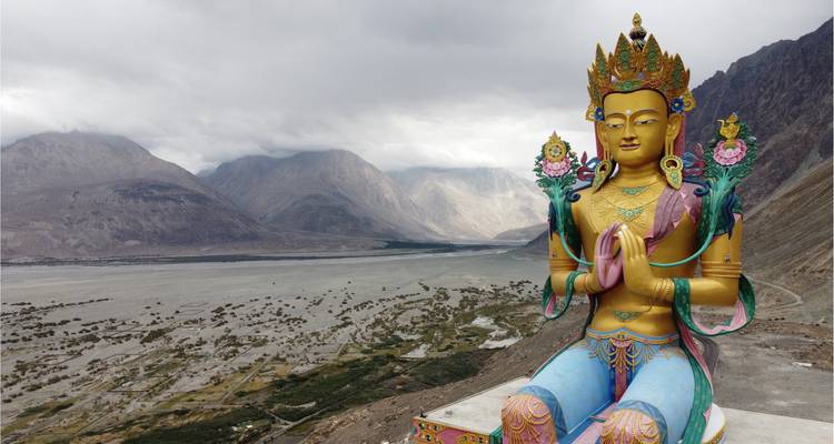 Large Buddha statue overlooking a vast valley.