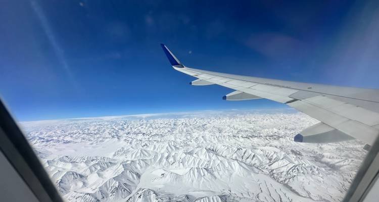 Aerial view of snowy mountain peaks from an airplane window.