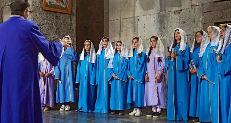 Gruppe junger Menschen in blauen Gewändern bei einer Aufführung.