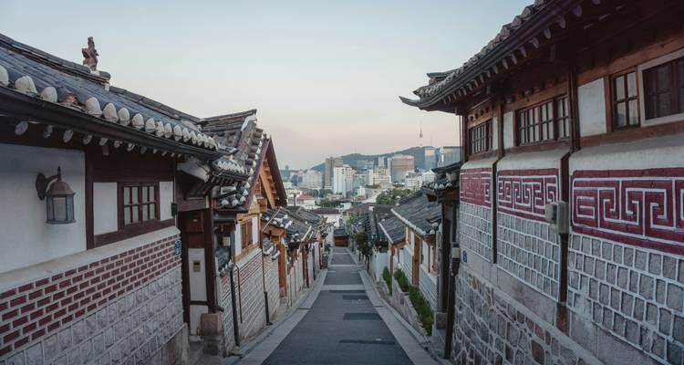 Traditional Korean street with tiled roof houses and cityscape view.