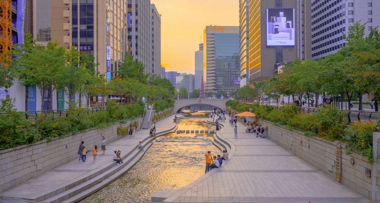 Urban river walk with people enjoying the vibrant city atmosphere.
