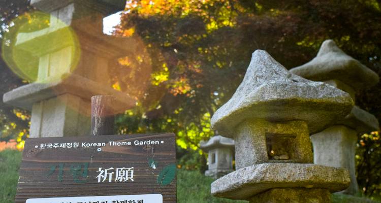 Stone lanterns with a sign at Korean Theme Garden.