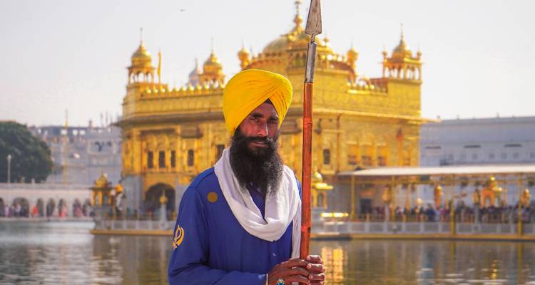 Guard with a spear standing in front of the Golden Temple.