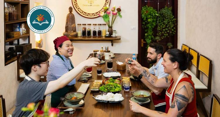 People enjoying a meal together indoors with a decorative backdrop.