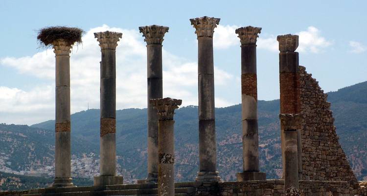 Series of ancient columns with a blue sky backdrop.