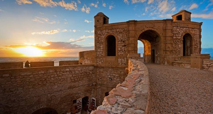 Forteresse de pierre au bord de la mer au coucher du soleil.