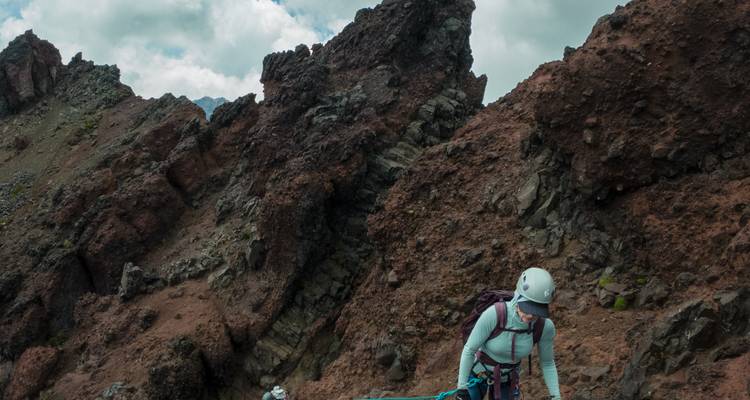 Geholmde klimmer gebruikt touwen om steile, grillige vulkanische rotsen hoog in de Andes te navigeren.