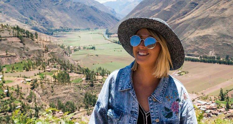 Personne portant un chapeau surplombant une vallée luxuriante.