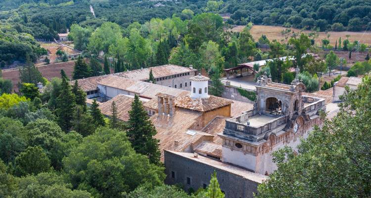 Historisches Kloster umgeben von Wäldern.