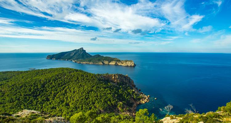 Küstenblick mit einer zerklüfteten Insel und tiefblauem Meer.