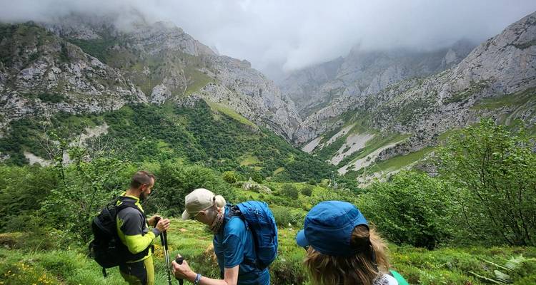 Hikers standing on a path with mountainous views in the background.