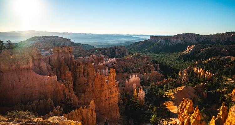 A sweeping view of a colorful canyon at sunrise.