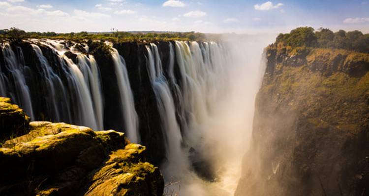 Les majestueuses chutes Victoria projettent des panaches de brume vers le ciel tandis que des torrents d'eau se précipitent dans les gorges.