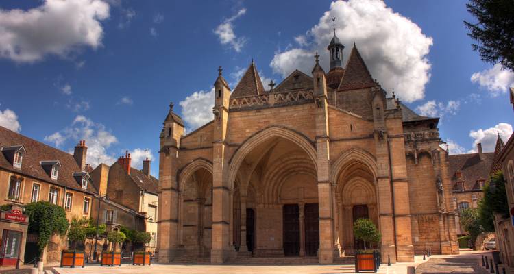 Une église historique avec plusieurs flèches sous un ciel lumineux.