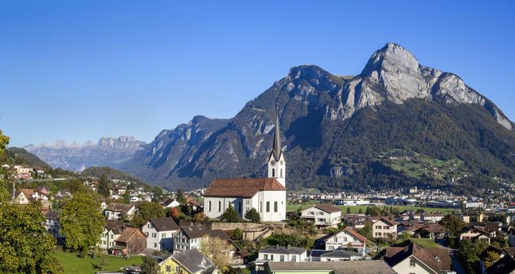 Montagnes pittoresques avec un village pittoresque et une église au premier plan.