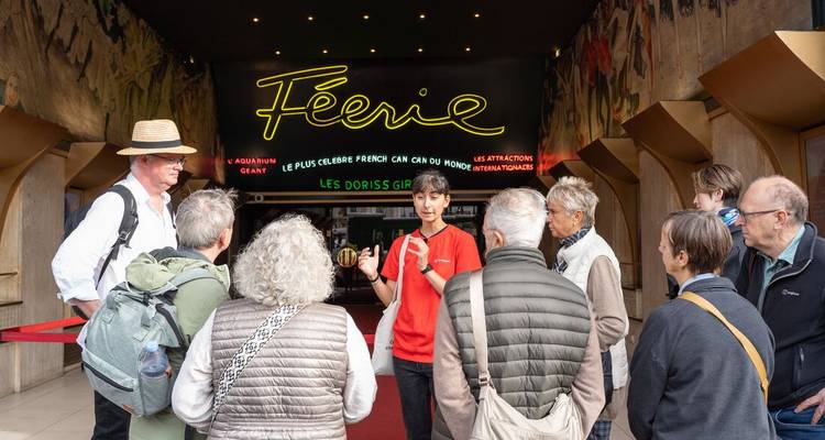 Guide touristique menant un groupe de personnes devant un lieu célèbre