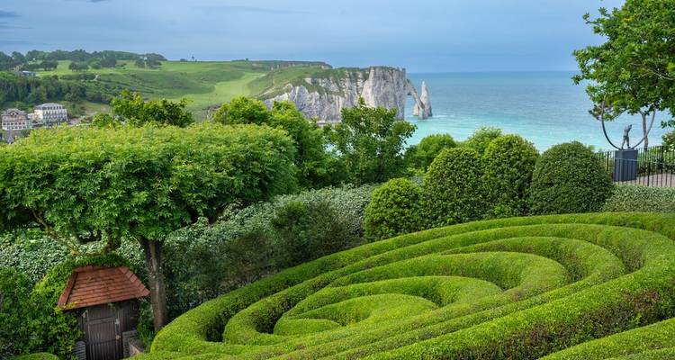 Vue panoramique des falaises et de l'océan avec un jardin en contrebas