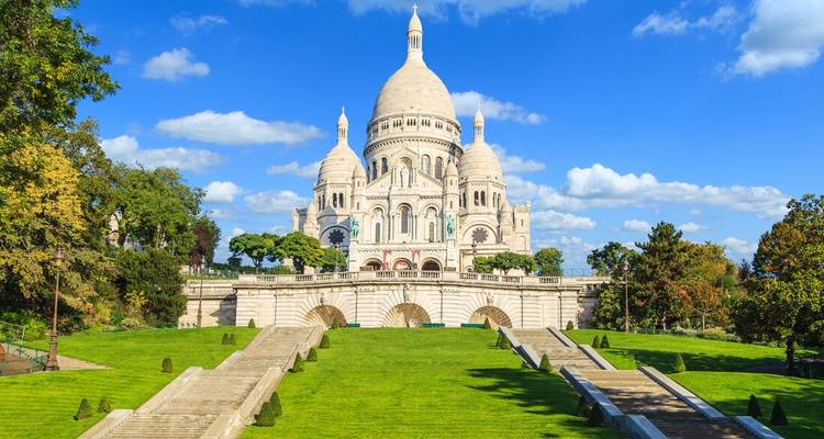 Vue de face de la Basilique du Sacré-Cœur avec des jardins luxuriants