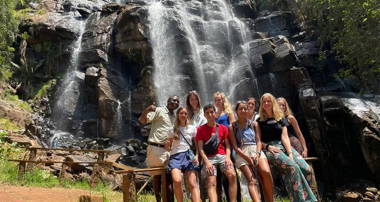 Groep mensen poseert voor een waterval.