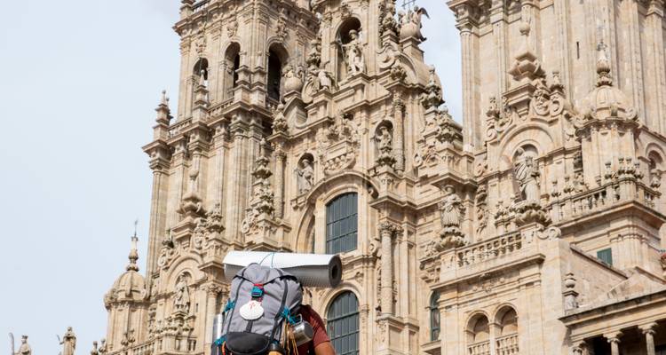 Backpacker standing in front of a cathedral façade.