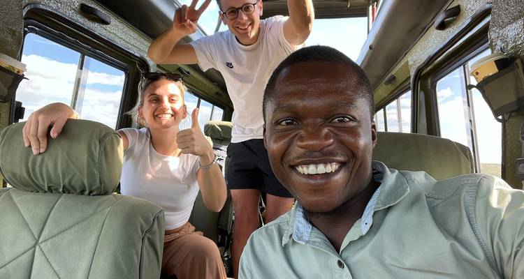 Selfie de groupe dans un véhicule de safari avec des personnes souriantes.