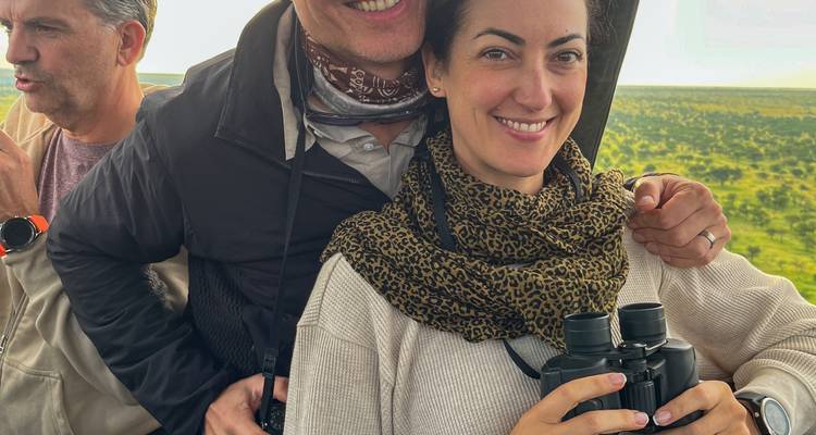 Couple souriant dans un cadre de safari avec des jumelles.