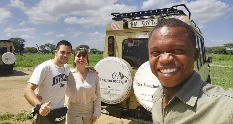 Selfie avec des personnes souriantes devant un véhicule de safari.