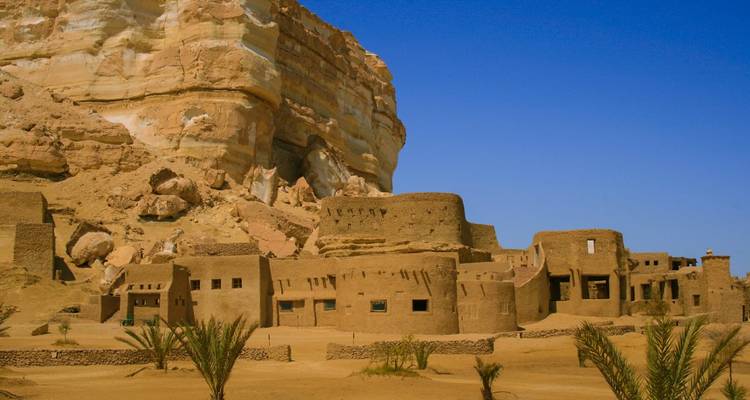 Ancien village de briques de terre situé contre une falaise rocheuse.