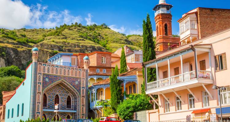 Levendige gebouwen met een heuvelflank op de achtergrond.