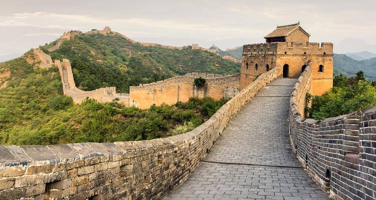 The Great Wall of China stretching through misty mountains.
