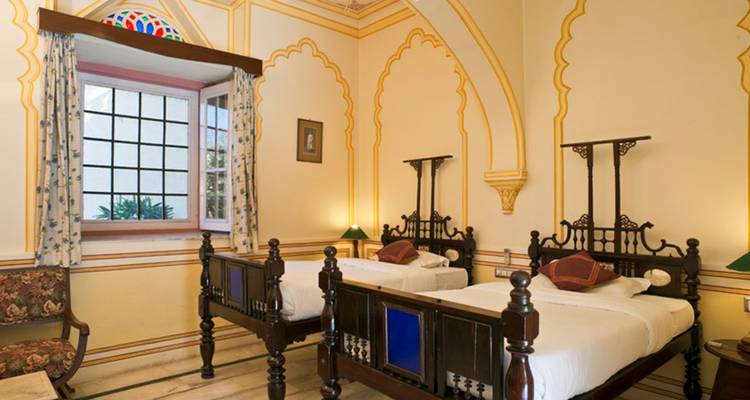 Une chambre d'hôtel décorée de manière traditionnelle avec deux lits.